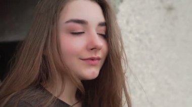 Dışarıdaki bir kızın portresi eski bir binanın arka planında.