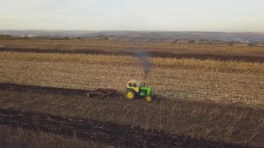 Küçük bir traktör mevsimin sonunda toprağı sürüyor, ekime hazırlanıyor, sonbaharın sonlarında.