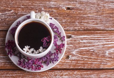 Kahve fincanı ve renkli leylak çiçekleri.