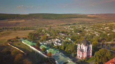 Etrafı sonbahar ormanlarıyla çevrili bir Hıristiyan manastırı üzerinde uçmak. Kurky Manastırı, Moldova Cumhuriyeti.