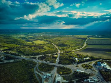 Akşam trafiği üzerinde uçan bir insansız hava aracı. Otoyol ve kamyonlar, kavşak, iki katlı yol ayrımı. Çevre yolu, hat.