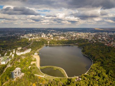 Sonbahar ağaçlarıyla dolu bir parktaki göl manzarası. Kishinev, Moldova. Suyun üzerinde destansı bir uçuş. Gündüzleri renkli sonbahar ağaçları.