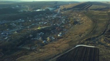 Merkezinde küçük bir kilise olan küçük bir köy. Hava görüntüsü. 4K.