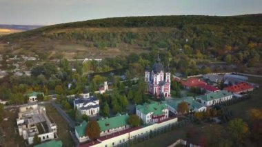 Etrafı sonbahar ormanlarıyla çevrili bir Hıristiyan manastırı üzerinde uçmak. Kurky Manastırı, Moldova Cumhuriyeti.