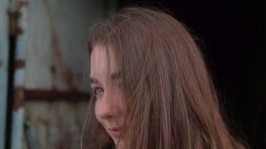 Dışarıdaki bir kızın portresi eski bir binanın arka planında.