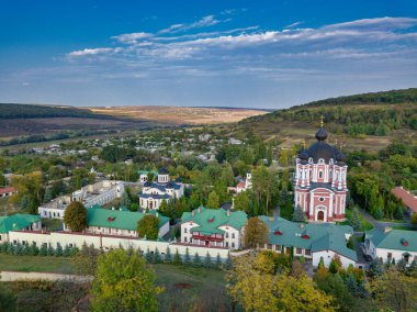 Etrafı sonbahar ormanlarıyla çevrili bir Hıristiyan manastırı üzerinde uçmak. Kurky Manastırı, Moldova Cumhuriyeti.