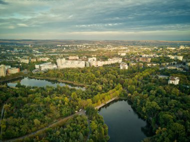 Sonbahar ağaçlarıyla dolu bir parktaki göl manzarası. Kishinev, Moldova. Suyun üzerinde destansı bir uçuş. Gündüzleri renkli sonbahar ağaçları.