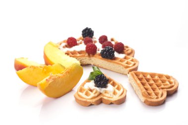 Beyaz arka planda yalıtılmış böğürtlen ve şeftalili waffle.