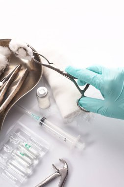 Kapalı el dişçisi hasta dişlerini tedavi etmek için bir araç seçiyor.