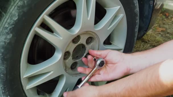 Automobile mechanic going to take off wheel during vehicle maintenance in car workshop. Close up. — Stock Video