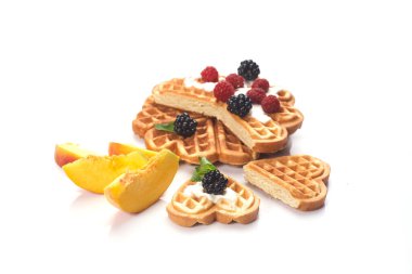 Beyaz arka planda yalıtılmış böğürtlen ve şeftalili waffle.