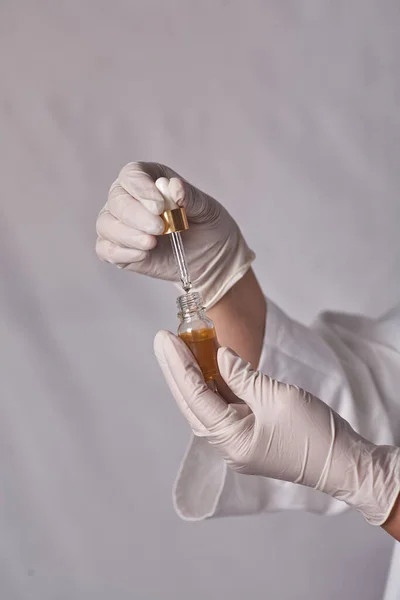 研究人员在实验室里把从吸管里取出的混合溶液放在瓶子里 — 图库照片