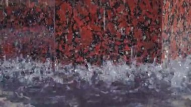 Damlaların ve fıskiyedeki su damlalarının yakın görüntüsü. Çeşmedeki mavi su parıldıyor ve parlıyor..