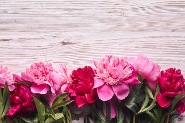 Gri ahşap arka planda pembe şakayıklar. Uzayı kopyala, üst görünüm. Anneler Günü, Sevgililer Günü, Doğum günü konsepti.