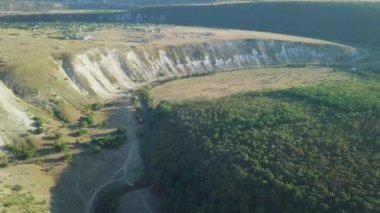 Kameranın derin kayalık bir vadi ve ormanın üzerindeki uçuşunun havadan görüntüsü..