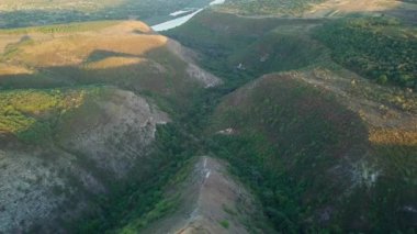 Kameranın derin kayalık bir vadi ve ormanın üzerindeki uçuşunun havadan görüntüsü..