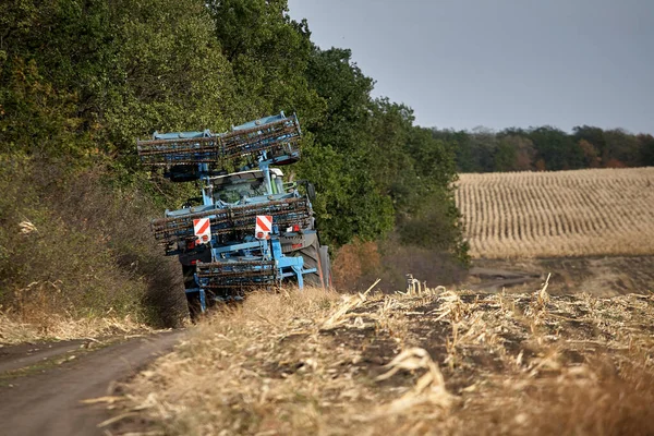 赤いトラクターフィールドを注ぐ 土地を耕すトラクター — ストック写真