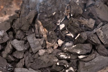 Yangın arka planında yanan siyah odun kömürü.