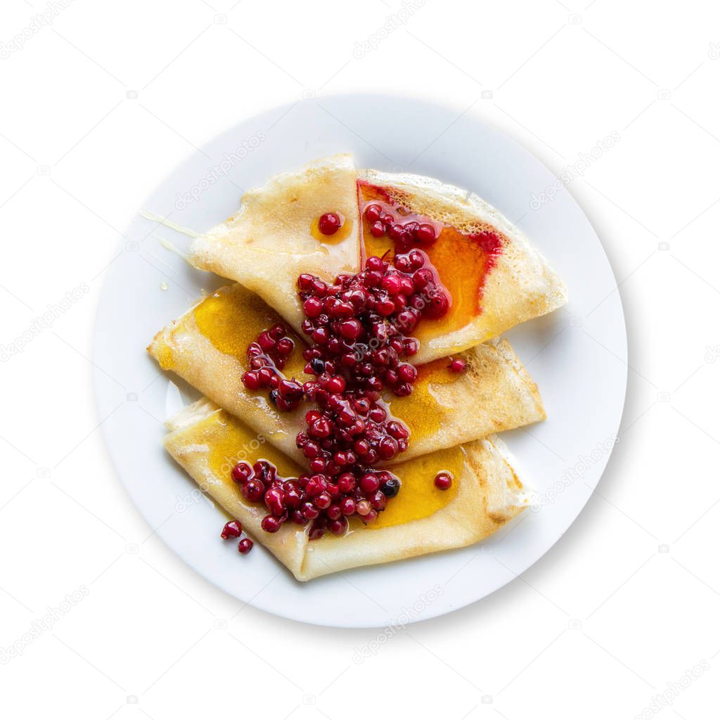 Pancakes with honey and cranberry jam on a plate, top view, isolated on white background