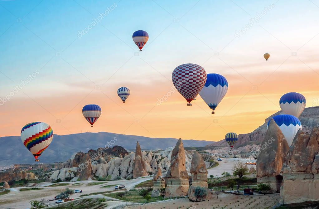 Bright multi-colored hot air balloons flying in sunsrise sky Cappadocia, Turkey