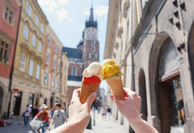 Krakow, Polonya, Avrupa, ünlü bir turistik yer tarihi merkezinde şehir manzaraları Mariatsky kilisenin arka planda dondurma ile kadın elleri