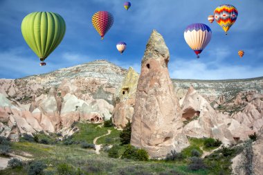 Mağara kasabası, Pembe Vadi, Kapadokya, Türkiye 'de gökyüzünde sıcak hava balonları