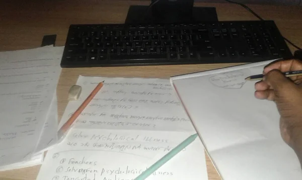 Draft paper, pen, keyboard on table