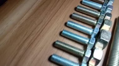 somun ve cıvata görüntüleri ahşap masada.