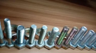 somun ve cıvata görüntüleri ahşap masada.