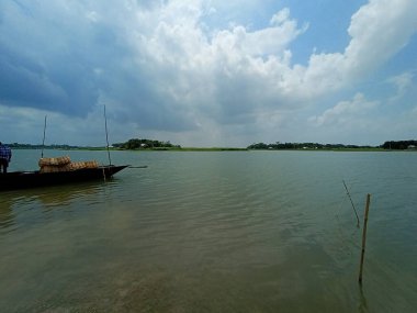 Nehirde gökyüzü ile siyah renkli ahşap tekne