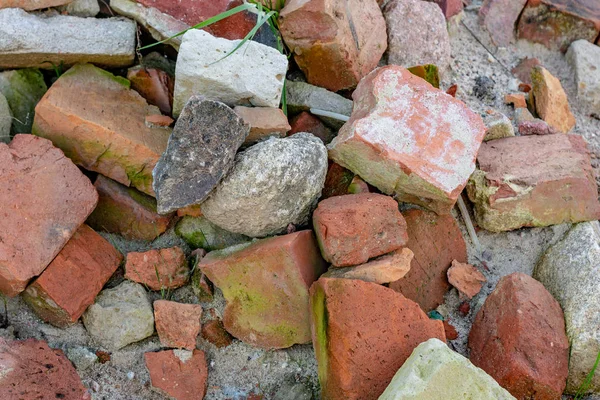 construction debris. grey stones, Orange bricks, sand