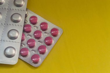 Kırmızı hap, tablet bir paket sarı bir arka plan üzerinde