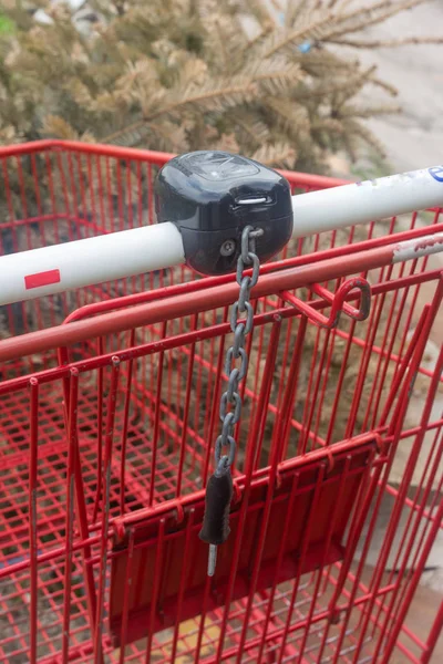 Red shopping cart with lock day outdoors close up — Stock Photo, Image