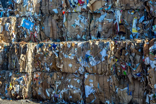 İsveç, Orebro, 24.02.2020: karton ve karton balyalar. Geri dönüşüm için atık kağıt. Kağıt dokularının arka planı, geri dönüşüm fabrikasındaki kağıt çöpleri.