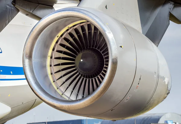 Engine turbine on fuselage of passenger plane, jet turbine and wing, aviation and aerospace industry on background blue sky