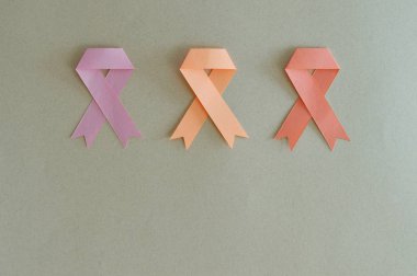 Strips of breast cancer, uterus and leukemia made with paper in beige background. clipart