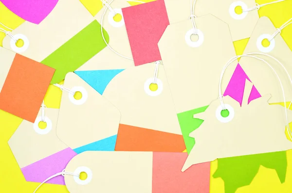 Bunch of colorful paper tags on yellow background horizontal tem — Stock Photo, Image