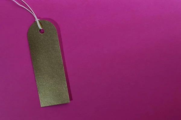 Etiqueta de papel rectángulo curvado oro sobre fondo rosa — Foto de Stock