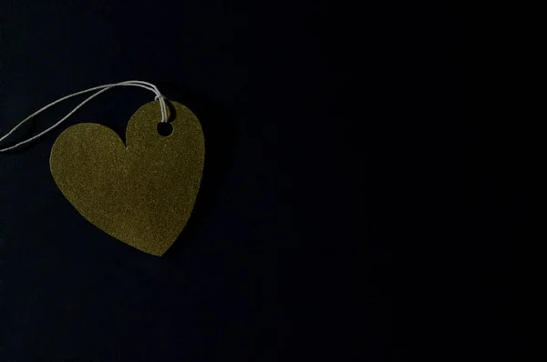 gold heart paper tag on dark background