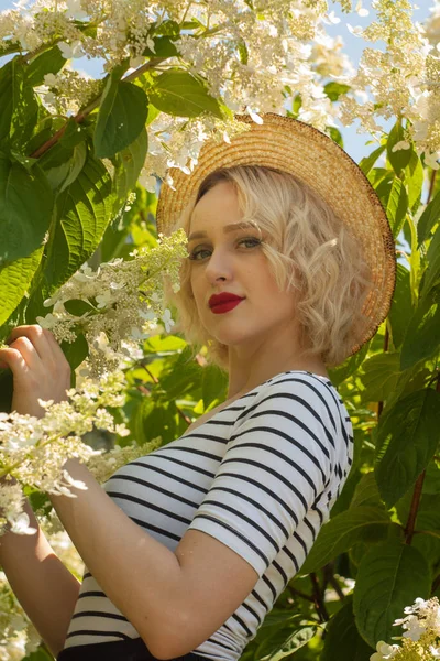 gülümseyen genç kadın kırmızı dudaklı beyaz çiçekler karşı