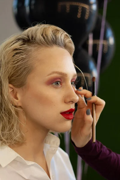 Güzeller güzeli sarışın bir kadının yakın plan portresi. Güzellik salonundan makyaj yaptırıyor.