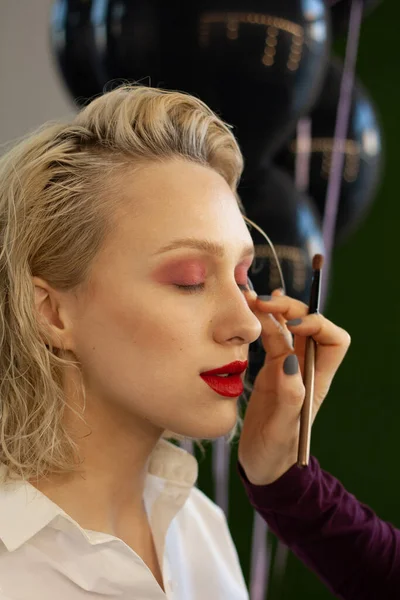 Güzeller güzeli sarışın bir kadının yakın plan portresi. Güzellik salonundan makyaj yaptırıyor.