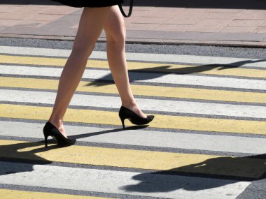 Güzel uzun kadın ayak üzerinde yaya geçidi. Kadın bir yaya geçidi, yol güvenliği, caddeyi geçerken yüksek topuklar üzerinde