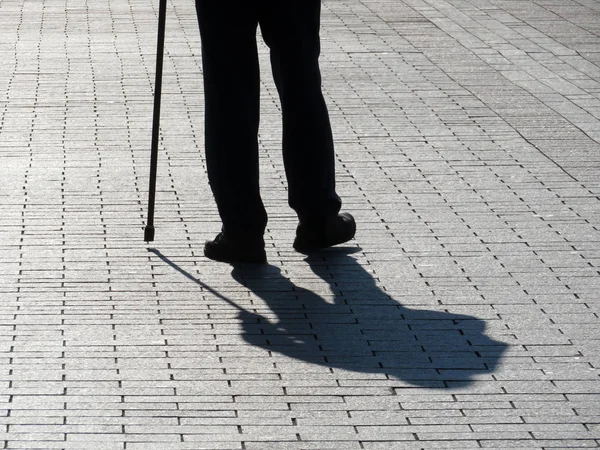 Silhueta Coxear Homem Andando Com Uma Bengala Sombra Longa Pavimento — Fotografia de Stock