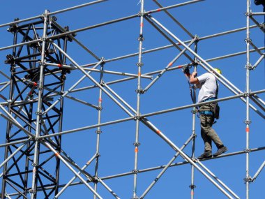İnşaat işçisi iskele üzerinde. Steeplejack açık mavi gökyüzü arka plan üzerinde