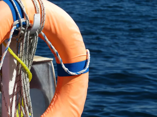 Orange life ring on the beach, water safety. Lifebuoy on the sea coast