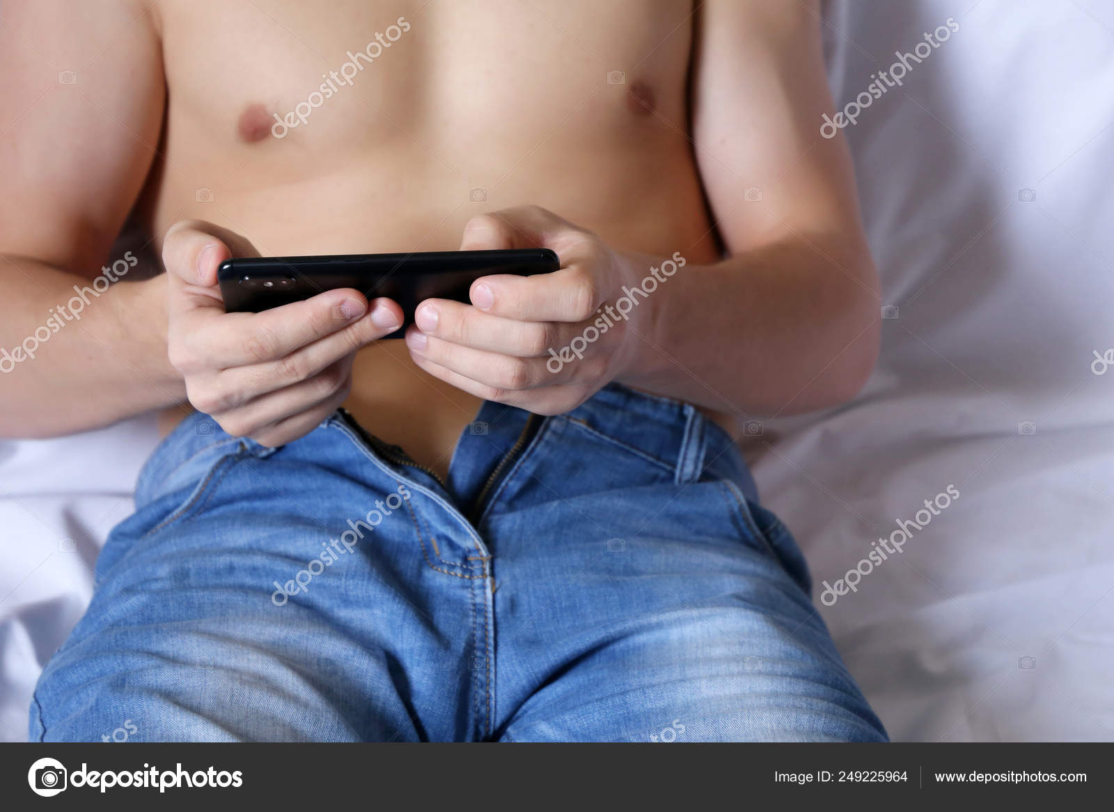 Smartphone Male Hands Man Unzipped Jeans Naked Torso Relaxing Bed Stock Photo by ©olegpmr 249225964 pic