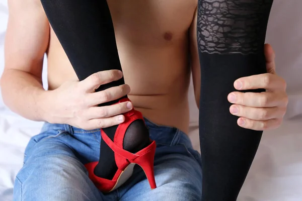 もてもてメルビン セックスする前にベッドでカップル 裸の胴体とジーンズで男は レースのストッキングとハイヒール 足フェチ 魅惑的な女性 情熱的な日付の概念上の赤い靴で女性の足を愛撫します — ストック写真