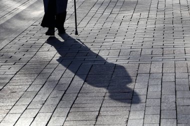 Silhouette ve kadın gölge bir baston ile yürüyüş. Kör kişi kavramı, Limping, özürlülük, yaşlılık, omurga hastalıkları, yabancı