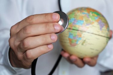 Elinde stetoskop ve küre olan doktor. Afrika'da sağlık, tıp kavramı, salgın kontrol, aşılama